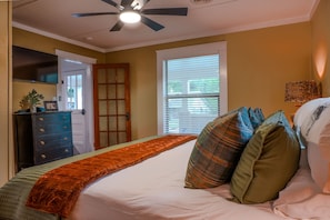 A bedroom with a bed, pillows, a dresser, a ceiling fan, and a window. - Cozy 2-bedroom in Cotter with walking distance to shopping, river, and food. (Cotter)