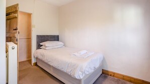 A single bed with white bedding in a room with a wooden door and a white wall. - 3 Bed in Stoborough (oc-c44898) (Stoborough)