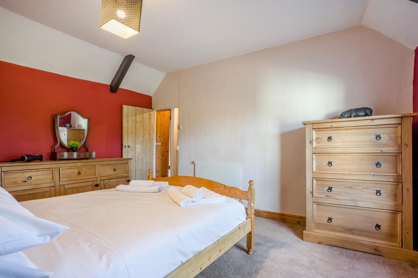 Ein Schlafzimmer mit einem Bett, einem Schminktisch und einem Spiegel.