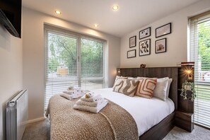 Ein modernes Schlafzimmer mit einem großen Bett, vielen Kissen, einer Heizung und einer Wand mit gerahmten Bildern.
