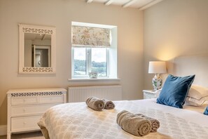 A bedroom with a bed, a nightstand, a lamp, a window with a view, and a radiator. - 3 Bed in Wirksworth (oc-l45749) (Hopton)
