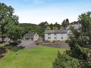 A residential area with stone buildings, a paved driveway, and a well-maintained lawn. - 3 Bed in Wirksworth (oc-l45749) (Hopton)
