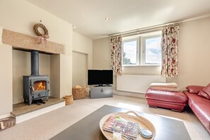 A living room with a fireplace, a television, a sofa, and a window with curtains. - 3 Bed in Wirksworth (oc-l45749) (Hopton)