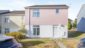 En toetages boligbygning med fladt tag, en hoveddør og en lille veranda.