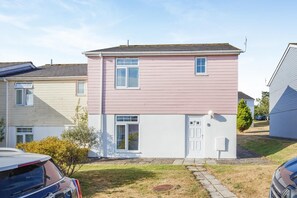 A two-story residential building with a flat roof, a front door, and a small porch area. - 4 Bed in Newquay (oc-a45833) (Black Cross)