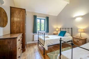 A bedroom with a wooden wardrobe, a bed with a metal frame, a window with curtains, and a bedside table with a lamp. - 2 Bed in Kenilworth (oc-p45550) (Kenilworth)