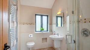 Un baño moderno con inodoro, lavamanos y ducha.