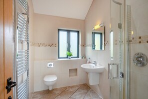 Ein modernes Badezimmer mit Toilette, Waschbecken und Dusche.