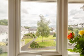 A window view of a residential area with houses, a tree, and a pathway. - 3 Bed in Borth-y-Gest (oc-t44960) (Borth-y-Gest)