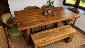 A wooden dining table with chairs, a bench, and a potted plant. - Antler Lake Haus - Private Waterfront & ATV/Snowmobile Trail Access (Bigfork)