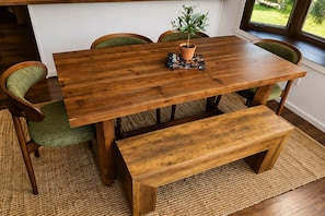 A wooden dining table with chairs, a bench, and a potted plant. - Antler Lake Haus - Private Waterfront & ATV/Snowmobile Trail Access (Bigfork)