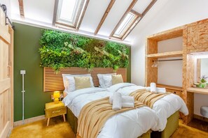 A bedroom with a bed, a bedside table, a wall-mounted plant, and a skylight.