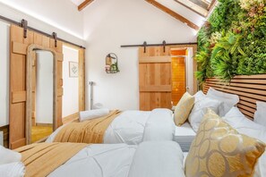 A bedroom with a bed, a wooden headboard, a wall-mounted plant, and a sliding door. - 2 Bed in Evercreech (oc-t40223) (Evercreech)
