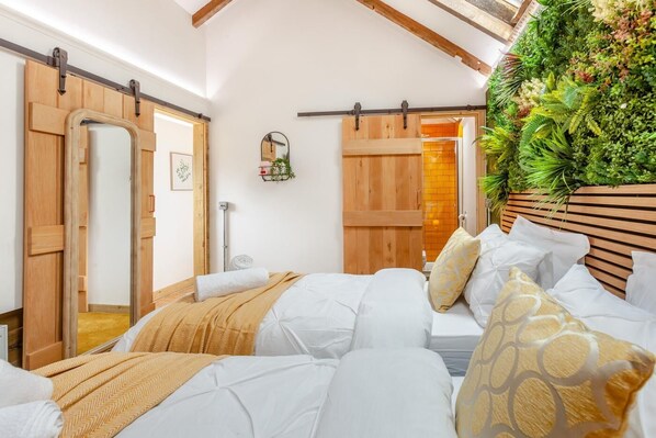 A bedroom with a bed, a wooden headboard, a wall-mounted plant, and a sliding door.
