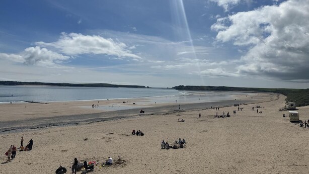 A beach with people, a lifeguard tower, and a clear sky. - 9 Bed in Tenby (oc-h45564) (Tenby)