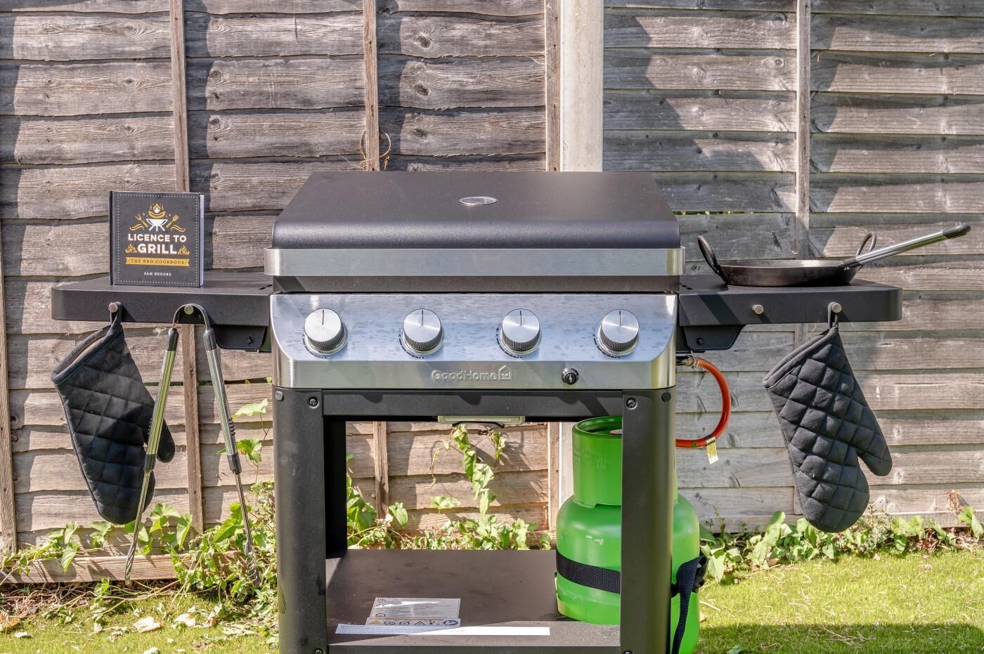 Un barbecue portable doté d’une plaque d’immatriculation, de deux boutons de réglage et d’une bouteille de gaz.
