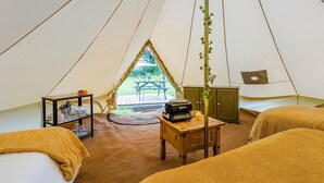 A tented accommodation with two beds, a table with a radio, and a view of an outdoor picnic area. - 1 Bed in St. Florence (oc-b33550) (Saint Florence)
