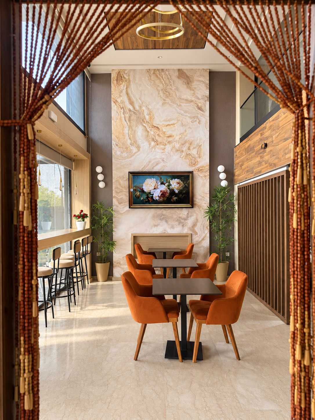 A modern interior with a marble wall, a painting, and a dining area with orange chairs and a table.