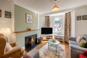 A living room with a fireplace, television, and seating area. - 3 Bed in Brixham (oc-c42670) (Brixham)