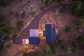 Luchtbeeld van een pand met een verharde oprit, zonnepanelen en een klein terras.