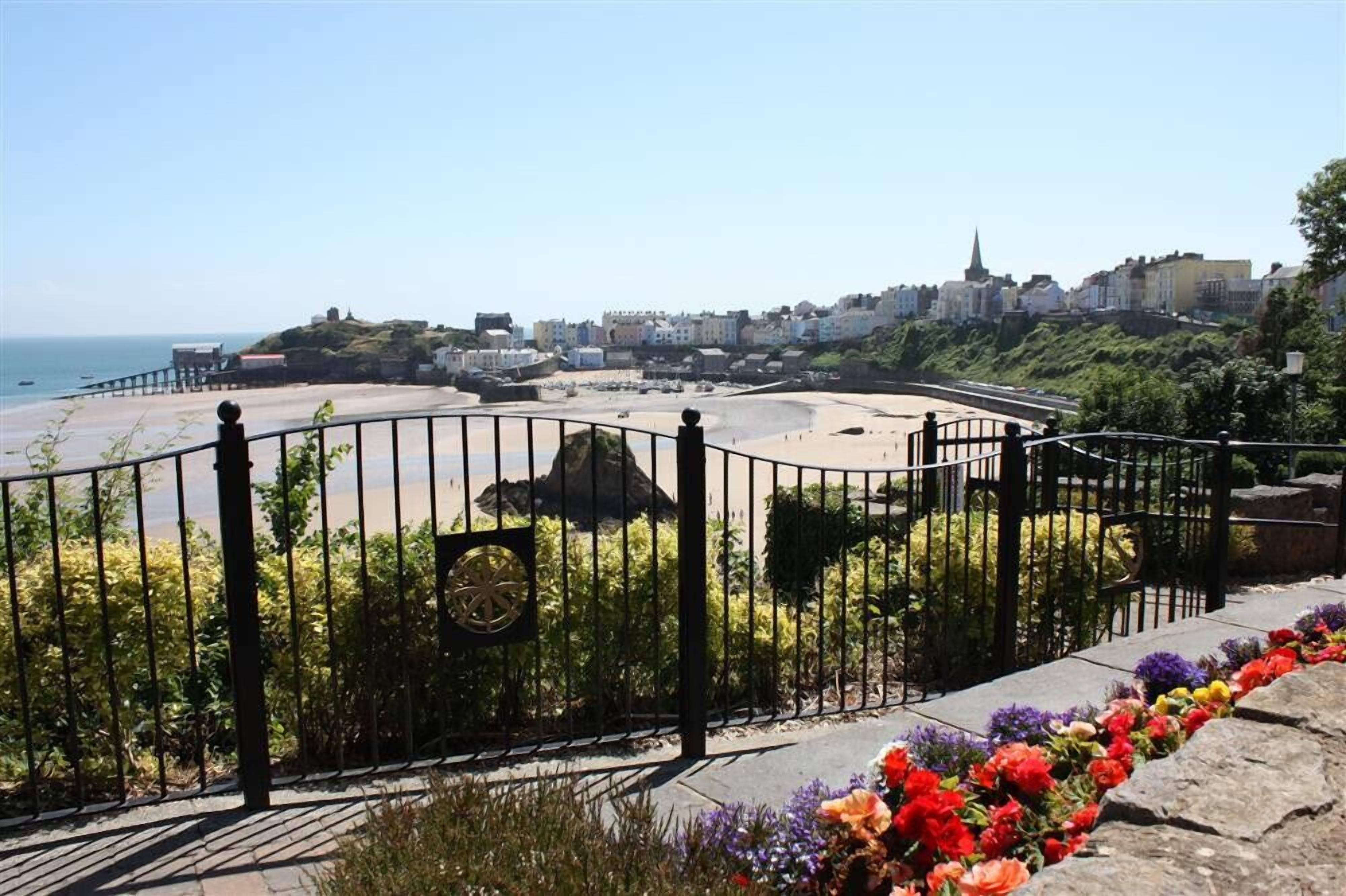 Blick auf die Küste mit Strand, Promenade und Gebäuden im Hintergrund.