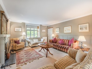 A spacious living room with a fireplace, a sofa set, a coffee table, and a patterned rug. - 5 Bed in Burton Pedwardine (oc-g42735) (Burton Pedwardine)