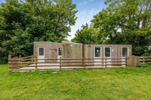 A wooden cabin with a fenced entrance, a small porch, and a door labeled 'Bathroom.' - 1 Bed in St. Florence (oc-p33549) (Saint Florence)