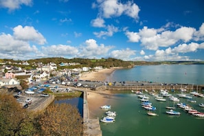 Une ville côtière dotée d’un port de plaisance, d’une plage de sable et de maisons construites le long du littoral.