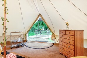 A tent with a view of a picnic table and greenery outside. Inside, there's a wooden dresser and a shelf with dishes. - 1 Bed in St. Florence (oc-p33549) (Saint Florence)