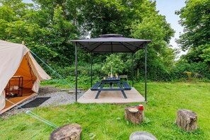 A camping setup with a tent, picnic table, and a covered seating area. - 1 Bed in St. Florence (oc-p33549) (Saint Florence)