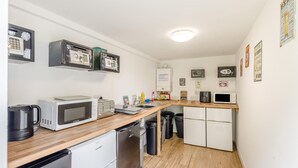 A compact kitchen with a microwave, toaster, and sink. There are black trash bins and a white refrigerator. - 1 Bed in St. Florence (oc-s33553) (Saint Florence)