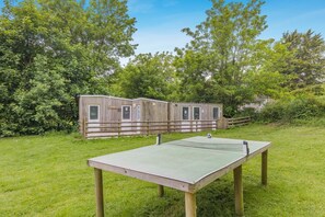 A portable wooden structure with windows, a ping pong table, and a grassy area. - 1 Bed in St. Florence (oc-s33553) (Saint Florence)