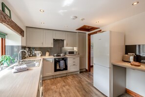 Eine moderne Küche mit Einbauofen, Mikrowelle und einem Bosch-Kühlschrank.