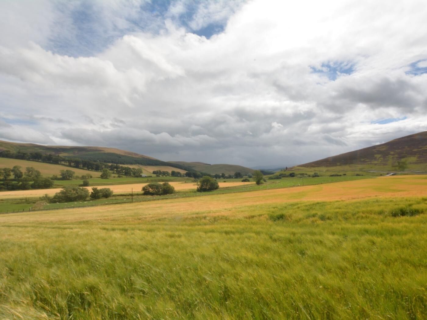 A rural landscape with rolling hills and fields.