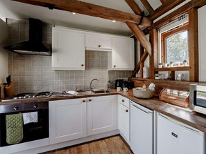 A modern kitchen with white cabinets, a gas stove, and a built-in oven. - 2 Bed in Brighton (oc-80378) (Poynings)