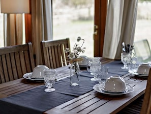 A dining table set with clear glassware, white plates, and a centerpiece of dried flowers. - 2 Bed in Brighton (oc-80378) (Poynings)