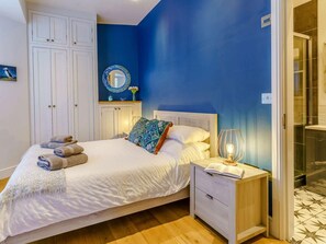 Ein Schlafzimmer mit einem Bett, einem Nachttisch und einem Spiegel.