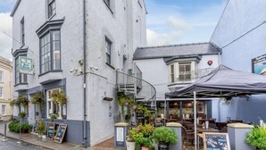 A building with a sign for 'Worcestershire Best Bitter' and outdoor seating with a covered area. - 1 Bed in Tenby (oc-85705) (Tenby)