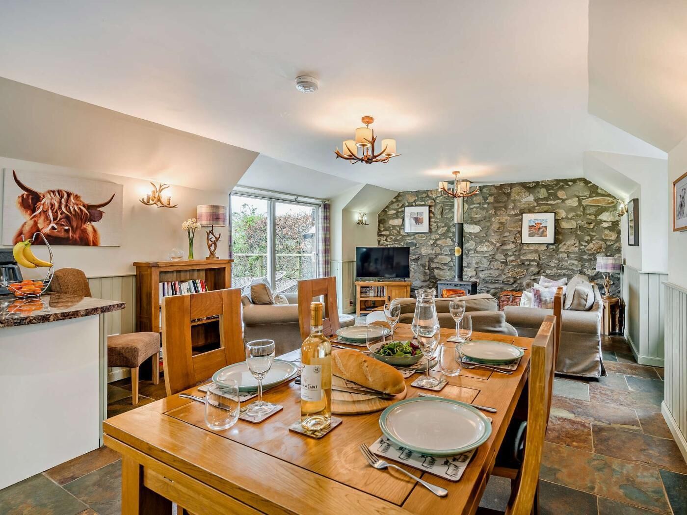 Comedor con pared de piedra, televisor y chimenea.