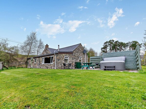 A stone house with a patio area, a hot tub, and a picnic table. - 2 Bed in Blairgowrie (oc-92112) (Blacklunans)
