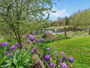 A natural landscape with a river, grassy areas, and purple flowers. - 2 Bed in Blairgowrie (oc-92112) (Blacklunans)