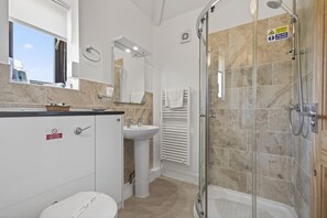 A modern bathroom with a glass shower enclosure, a sink, and a toilet. - 1 Bed in Milton Abbas (oc-a35016) (Milton Abbas)
