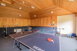 A ping pong table with exercise equipment and weights in a room with wooden walls and ceiling. - 1 Bed in Milton Abbas (oc-c35017) (Milton Abbas)