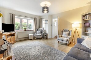 A living room with a television, two armchairs, a sofa, a floor lamp, and a bookshelf. - 3 Bed in Guist (oc-h33647) (Guist)