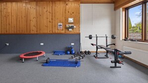 Ein Fitnessstudio mit Trampolin, Gewichten und einem Fenster mit Blick.