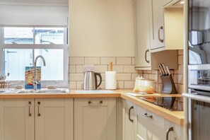 Eine moderne Küche mit Spüle, Wasserkocher und Brot auf der Arbeitsplatte.