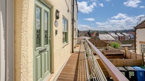 A balcony with a view of a town, a door with a number plate, and a railing. - 2 Bed in Whitby (oc-m32879) (Whitby)