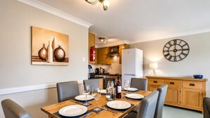 Comedor con una mesa de madera dispuesta para cuatro personas, rodeado de sillas.