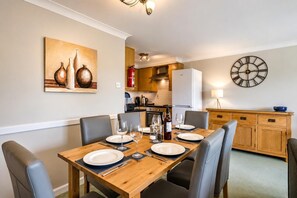A dining area with a wooden table set for four, surrounded by chairs. - 2 Bed in Barnham Broom (oc-s42613) (Barnham Broom)