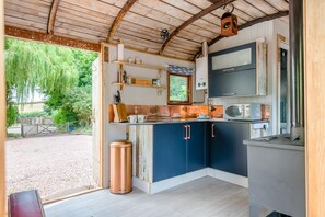A rustic kitchen with wooden beams, a sink, and a microwave. - 1 Bed in Longhope (oc-m45889) (Longhope)